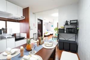 a kitchen and living room with a table in a room at Retreat Ginoza in Ginoza