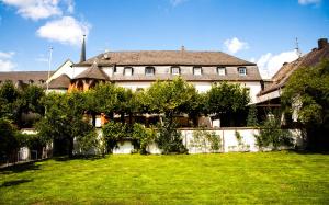 ein großes Haus mit grünem Rasen davor in der Unterkunft Boutiquehotel Kloster Pfalzel in Trier
