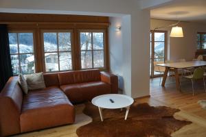 ein Wohnzimmer mit einem braunen Sofa und einem Tisch in der Unterkunft Chalet Alsegg in Bad Gastein