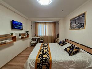 a bedroom with a large bed and a dining room at Apartments Chisinau in Chişinău