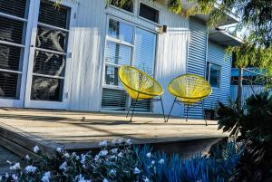 two yellow chairs sitting in front of a house at Eco Retro Aldinga Beach House in Aldinga Beach