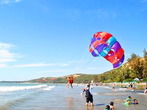 a group of people on a beach flying a kite at Hon Rom Central Beach Resort in Mui Ne