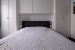 a bedroom with a white bed and white cabinets at Appartement Ann in Blankenberge