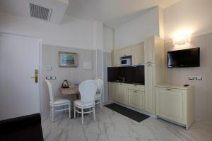 Hotel Residence Villa Del Mare في ريميني: غرفة مع مطبخ وطاولة مع كراسي
