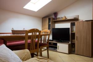 uma sala de estar com uma mesa de jantar e uma televisão em Apartment Perc em Koper