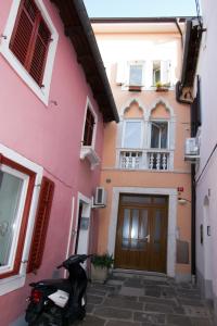 a scooter parked in front of a pink building at Apartment Perc in Koper