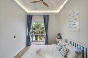 a bedroom with a bed with a ceiling fan at CASA Villa NOVAWORLD Phan Thiet in Phan Thiet +67 photos