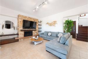 a living room with a blue couch and a fireplace at Villa Leyland in Faliraki