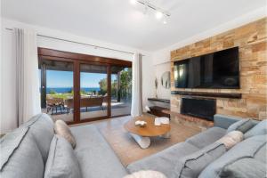 a living room with a couch and a tv at Villa Leyland in Faliraki