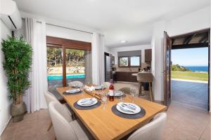 a dining room and living room with a table and chairs at Villa Leyland in Faliraki