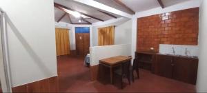 a kitchen with a table and a brick wall at Mítica, Casa Hospedaje in Sauce