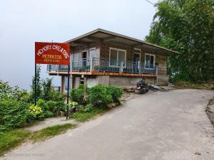 a house with a motorcycle parked in front of it at Petratos Homestay in Kalimpong