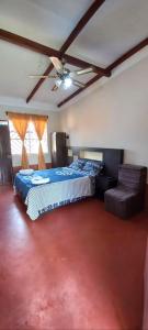 a bedroom with a bed and a ceiling fan at Mítica, Casa Hospedaje in Sauce +25 photos