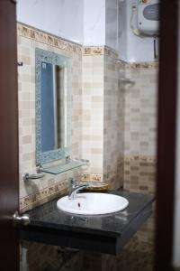 a bathroom with a sink and a mirror at Bảo Cường Hotel in Hương Hóa +10 photos