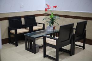 a table and two chairs and a vase with flowers at Bảo Cường Hotel in Hương Hóa