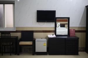 a room with a mirror and a dresser and a tv at Bảo Cường Hotel in Hương Hóa