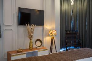 a bedroom with a television and a table with a vase at Sunoraa Luxury Hotel & Spa in Mussoorie