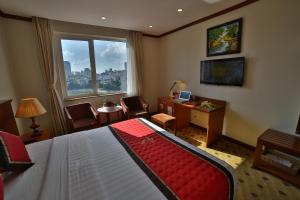 a bedroom with a bed and a desk and a window at Sunny Hotel 1 in Hanoi