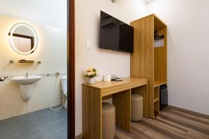 a bathroom with a sink and a toilet and a television at Phuong Nam Hotel in Ho Chi Minh City