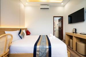 a hotel room with a bed and a flat screen tv at Phuong Nam Hotel in Ho Chi Minh City