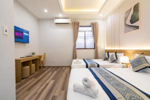 a hotel room with two beds and a desk at Phuong Nam Hotel in Ho Chi Minh City