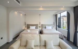 a hotel room with two beds and a couch at 样样好民宿 in Jinghong +2 photos