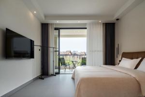 a bedroom with a bed and a tv and a balcony at 样样好民宿 in Jinghong