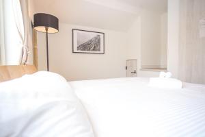 a bedroom with two white beds and a lamp at Grouse Lodge -5 mins to ski field by walk- in Furano