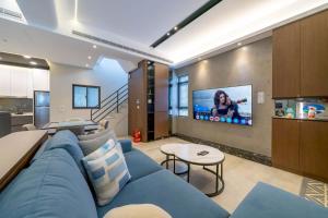 a living room with a blue couch and a tv at Sunlight Heyun B&B in Yuanshan