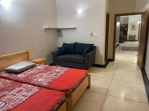 a bedroom with a bed and a couch and a chair at New Apartment in Islamabad