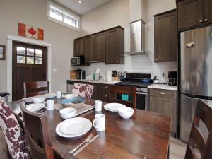 a kitchen with a wooden table with plates and bowls on it at Amazing Oceanfront & Eagle Views pet Friendly - 2 bath in Port Renfrew