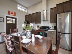 a kitchen with a wooden table and a refrigerator at Amazing Oceanfront & Eagle Views pet Friendly - 2 bath in Port Renfrew