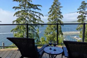 a table with two glasses of wine on a balcony at Amazing Oceanfront & Eagle Views pet Friendly - 2 bath in Port Renfrew +20 photos