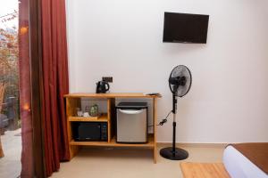 a room with a desk with a fan and a tv at Velora Inn in Ella