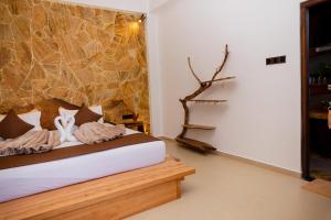 a bedroom with a bed and a stone wall at Velora Inn in Ella