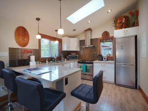 a kitchen with a large island with blue chairs at Tiltin Hilton- Ocean View - Pet Friendly - sleep 4 in Port Renfrew