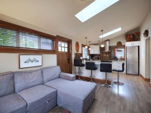 a living room with a couch and a kitchen at Tiltin Hilton- Ocean View - Pet Friendly - sleep 4 in Port Renfrew