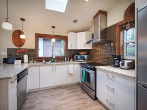 a kitchen with white cabinets and a stove top oven at Tiltin Hilton- Ocean View - Pet Friendly - sleep 4 in Port Renfrew