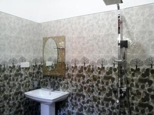 a bathroom with a sink and a mirror and a shower at Hill House Rest in Mirissa