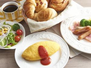 a table topped with plates of food with pastries and bread at The Yokohama Bay Hotel Tokyu in Yokohama