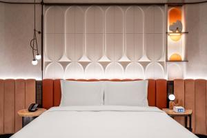 a bedroom with a large bed with white sheets at Hotel Indigo Xi'an High-tech Zone by IHG in Xi'an