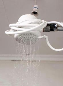 a shower head with water hanging from it at Haven one bedroom in Busia +5 photos