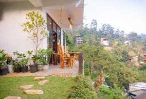 a porch of a house with a table and chairs at Velora Inn in Ella