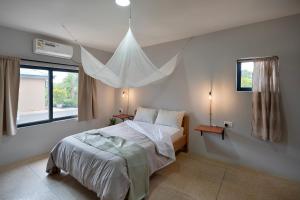a bedroom with a bed with a mosquito net over it at The Drift Cottage in Livingstone