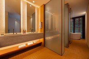 a bathroom with a shower and a tub and a sink at The Cut Hotel in Medellín