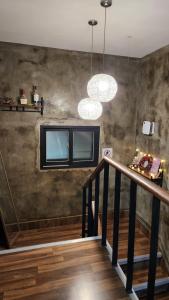 a room with a staircase with two windows and a chandelier at SPACE Guesthouse in Seoul