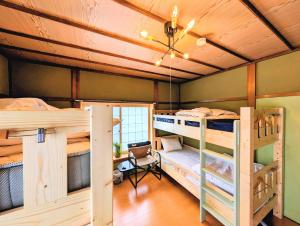 a room with two bunk beds and a desk at Kaido Urasa CoLiving in Minami Uonuma