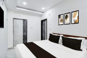 a white bedroom with a black and white bed at Super Collection O Kachiguda Bus Terminal Hyderabad in Vidya Nagar