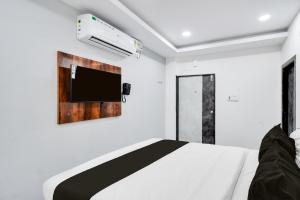 a bedroom with a bed and a tv on the wall at Super Collection O Kachiguda Bus Terminal Hyderabad in Vidya Nagar +35 photos