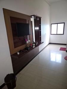 a living room with a flat screen tv on a wall at Om Hotel & Lodge in Baharāgora